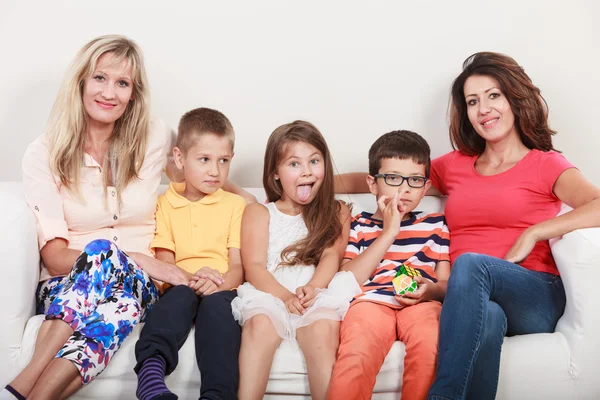 Szczęśliwa rodzina. Matek i dzieci na kanapie w domu. — Zdjęcie stockowe