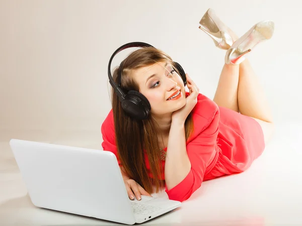 Menina com fones de ouvido e laptop — Fotografia de Stock