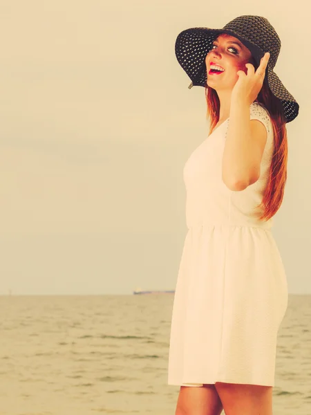 Beautiful redhaired happy girl in heart shaped sunglasses on beach. — Stock Photo, Image