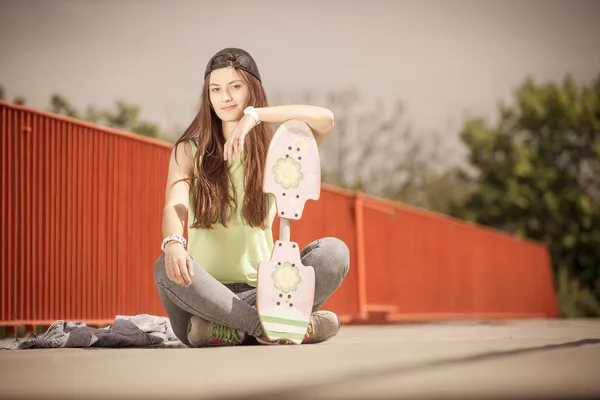 Σκέιτερ κορίτσι wth skateboard συνεδρίαση — Φωτογραφία Αρχείου