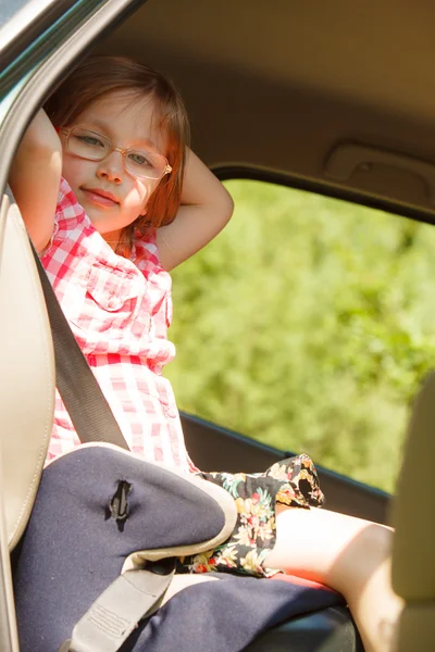 Weg en veiligheid. Klein meisje in de autostoel zitten. — Stockfoto
