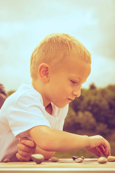 Little boy clever child playing checkers in park — Stock Photo, Image