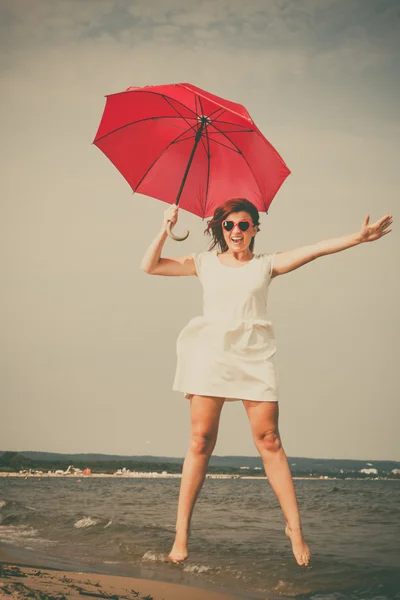 Menina pulando com guarda-chuva vermelho — Fotografia de Stock