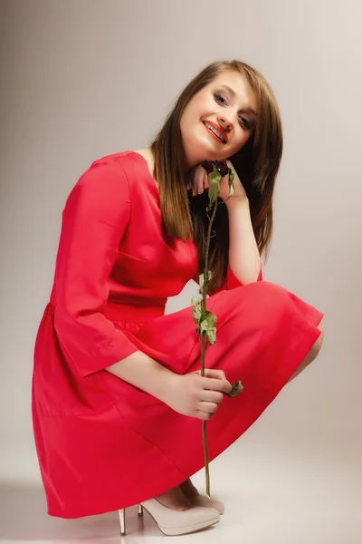 Fashion vrouw tiener meisje in rode jurk met droge roos. — Stockfoto
