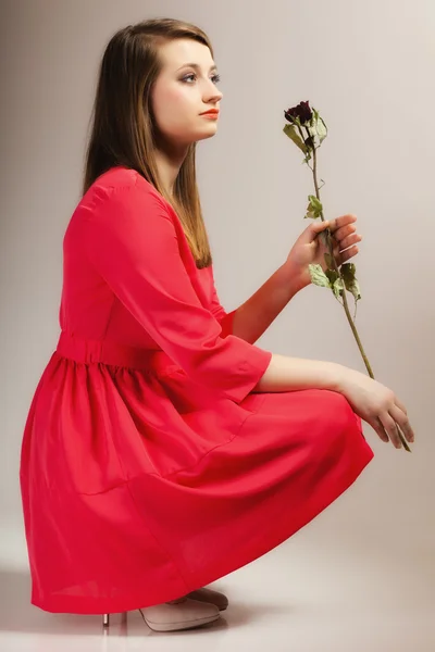Módní žena teen dívka v červených šatech se suché růže. — Stock fotografie