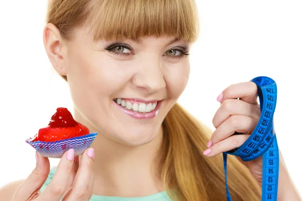 Frau hält Cupcake und Maßband. Ernährung — Stockfoto