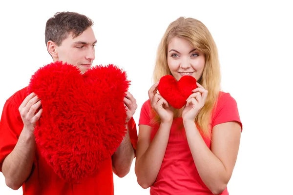 Couple holds red heart shaped pillows love symbol — Stock Photo, Image