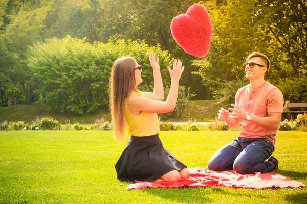 Pareja con gran corazón en el picnic — Foto de Stock