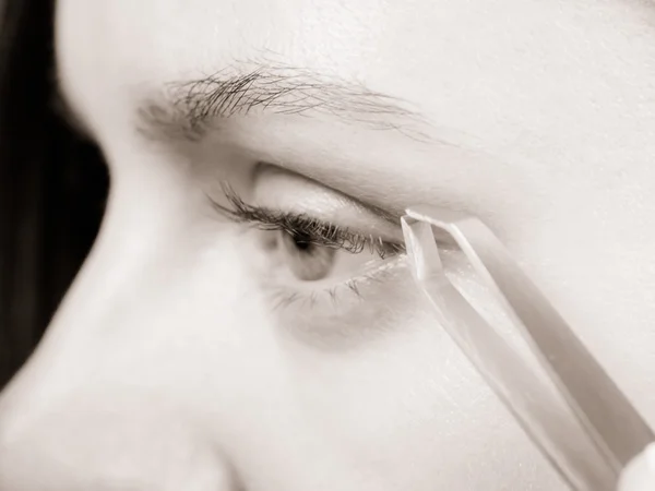 Woman tweezing eyebrow — Stock Photo, Image