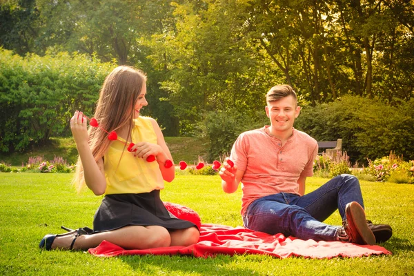 Pareja con collar de corazones en el picnic —  Fotos de Stock