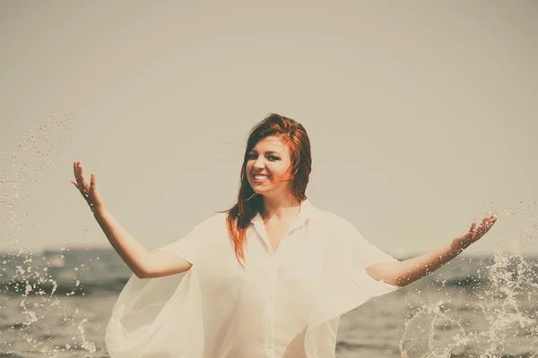 Chica salpicando agua en la costa. —  Fotos de Stock