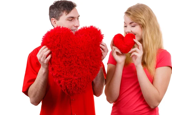 Couple holds red heart shaped pillows love symbol — Stock Photo, Image