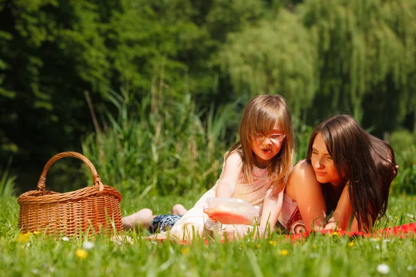 Mor och dotter lilla flickan ha picknick i parken — Stockfoto