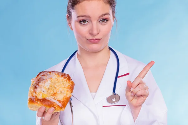 Dietitian with sweet roll bun. Unhealthy junk food — Stock Photo, Image