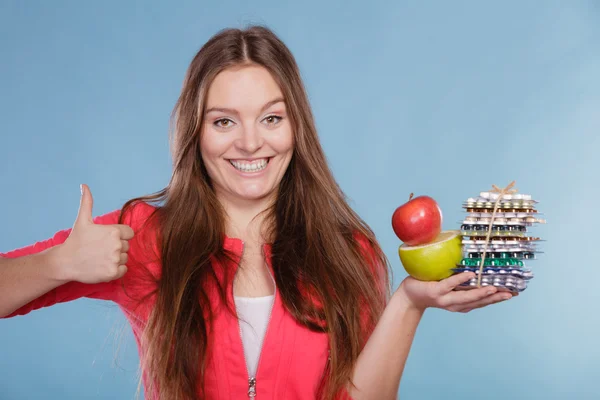 Mujer sosteniendo pastillas y frutas. Asistencia sanitaria —  Fotos de Stock