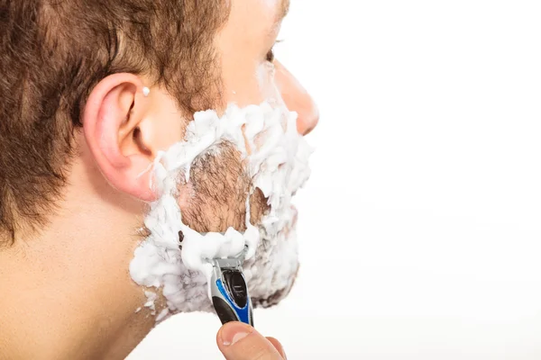 Homem de barbear usando lâmina com espuma de creme . — Fotografia de Stock
