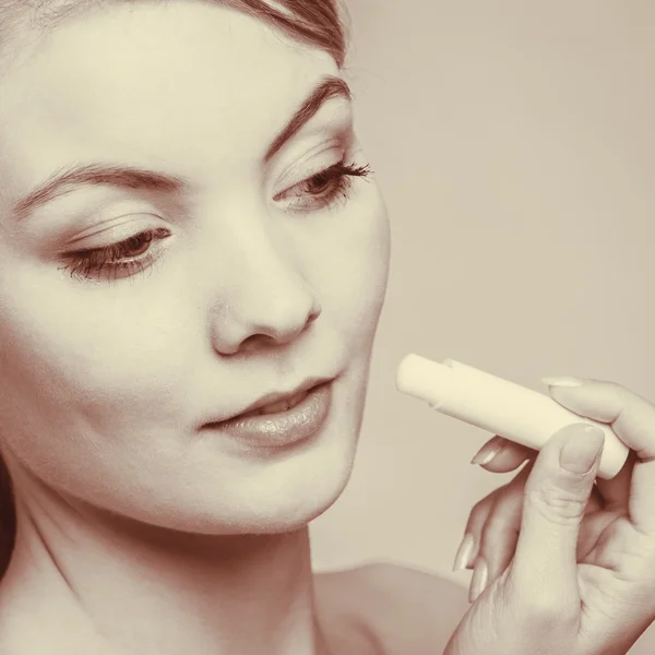 Frau setzt Lippenbalsam auf. — Stockfoto