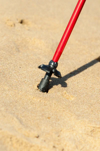 Nordic walking. Czerwony patyk na piaszczystej plaży — Zdjęcie stockowe