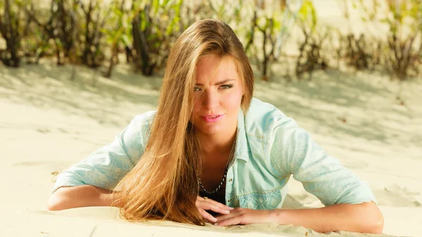 Young woman lying on grassy dune — Stock Photo, Image