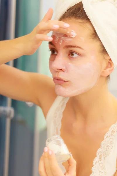 Woman applying mask cream on face in bathroom — Stock Photo, Image