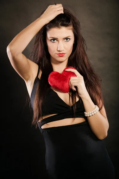Güzel kadın siyah üzerine kırmızı kalp tutar — Stok fotoğraf