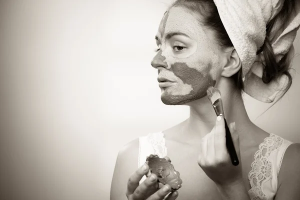 Woman applying with brush clay mud mask to her face — Stock Photo, Image