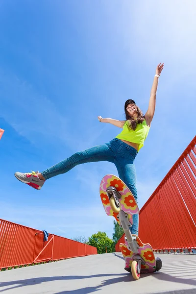 Dospívající dívka bruslař na koni skateboard na ulici. — Stock fotografie