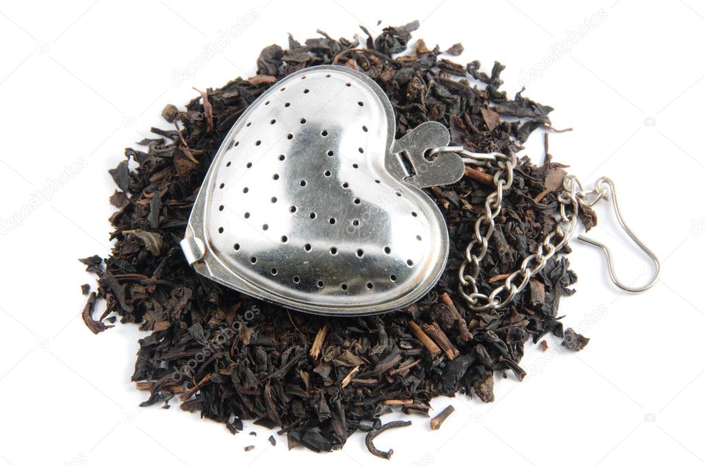 Dried tea in tea-strainer on white background