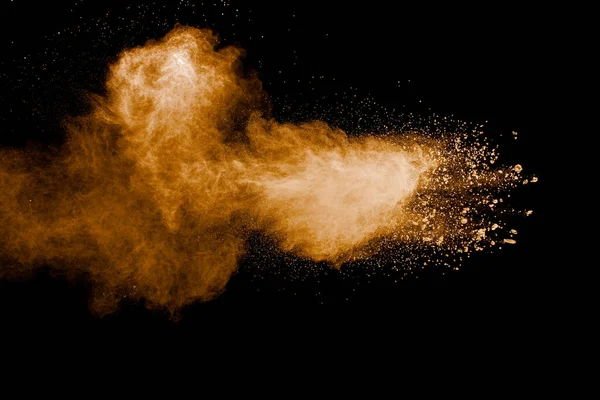 Kahverengi toz patlamasının hareketsiz hareketi. Kahverengi toz hareketinin tepesinde. Siyah zemin üzerinde patlayıcı kahverengi toz..