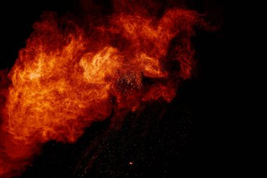 Portakal tozu siyah zemine sıçramış. Soyut toz bulutu arkaplanı.