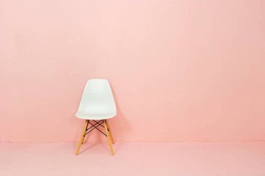 Beyaz sandalye turuncu arka planda, reklam metinleri için yer var.