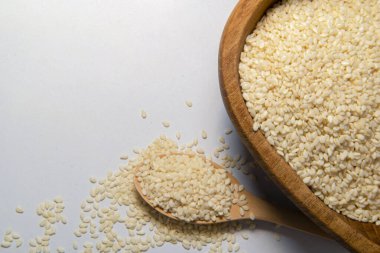 Gri izole arka planda beyaz susam tohumları veya kaşıklarda kimyon, üst görünüm, kapat