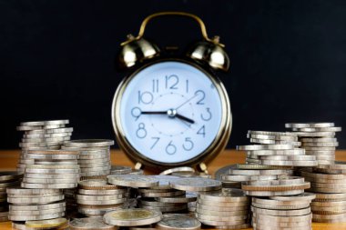 Alarm saati ve para basamaklarının çalışma masasındaki basamakları, tasarruf parası konsepti, bankacılık ve iş fikri zamanı. 