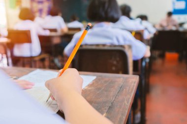 Okul öğrencisi, eğitim ve okur yazarlık, eğitim ve dünya okur yazarlık günü konsepti için sınıfta sınav yazma cevabı alıyor