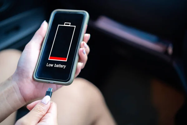 Asyalı genç kadınlar arabalarında akıllı telefonlar kullanırlar. Araç konseptinde pili şarj et