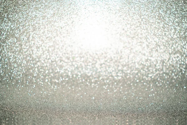 Silver Sparkling Lights Festive background with texture. Abstract Christmas twinkled bright bokeh defocused and Falling stars. Winter Card or invitation