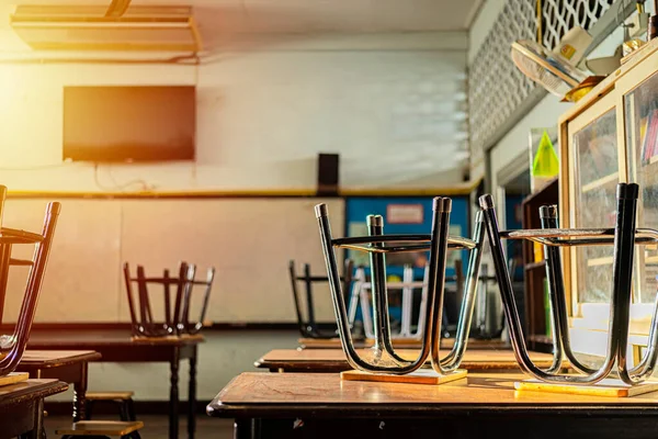 Lecture room or School empty classroom with desks and chair iron wood for studying lessons in high school thailand, interior of secondary education, with whiteboard, vintage tone educational concept