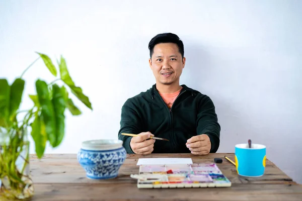 Egy Ázsiai Férfi Művész Festett Egy Ecsettel Egy Akvarell Paletta — Stock Fotó