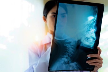 Doktor röntgen filmi çekiyor. Kafatası ve servikal omurilik. Hastanenin sol tarafında boş bir bölge var.