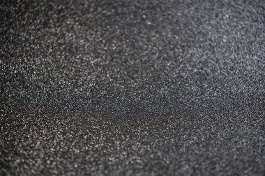 Siyah arkaplanda siyah bokeh dokusu. Pırıl pırıl ışıklar arka plan. Altın, gümüş, mavi ve siyah. Odaklanmamış.