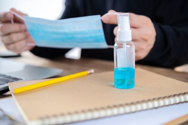 Ellerini alkol spreyi ve alkol jeliyle yıkayarak masalarında çalışırlar ve Corona Virüsü veya Corona Virüsü Hastalığı 'nı (Covid-19) önlerler. Şiddetli bir salgını önleme kavramı