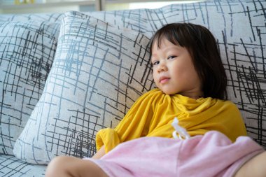 Onun yakın plan portresi. Çekici, sevimli, sevimli, sevimli, sevimli, sakin, huzurlu, çocuksu, divanda uzanan, açık beyaz, iç mekan oturma odasında dinlenen kız.