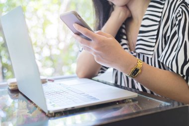 Kafede telefon, akıllı telefon ve bilgisayar kullanan bir kadın. İlgi çekici bilgileri bul