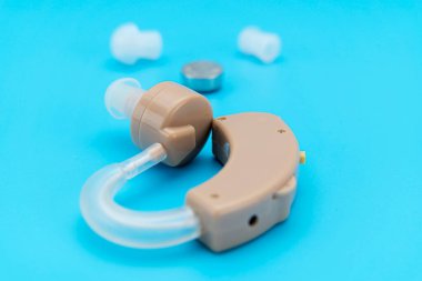 İşitme cihazı ve mavi arkaplanda kömür. 