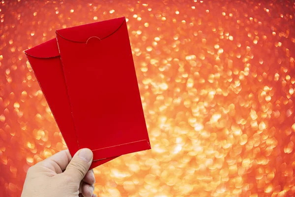 Red envelope packet chinese new year 2021 in hand red, gold bokeh background for Chinese New Year