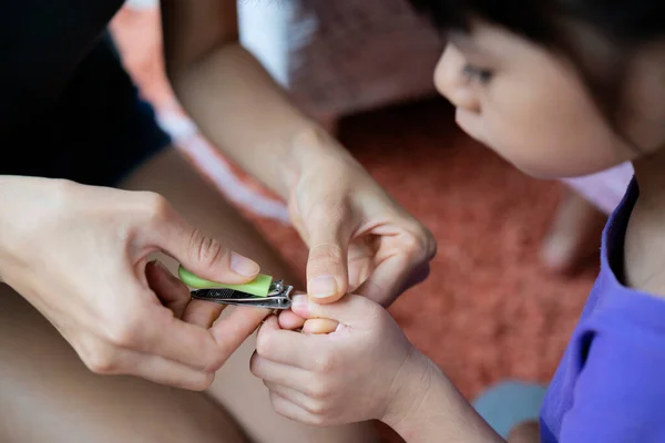 Young Mother Sitting Bed Carefully Cuts Her Daughter Finger Nails — Stock Photo, Image