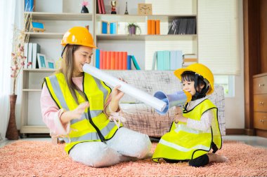 Bir Asyalı anne ve kız, planlar ve rol yapma ekipmanı olarak bir megafon ile kumanda mühendisi olarak görev yapıyor..