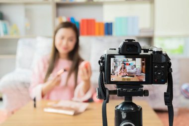 İş yerindeki kendine güvenen güzel Asyalı kadınların portresi internette kozmetik ve renkli ruj satışı için video blogu hazırlıyor. Çevrimiçi Alışveriş e-Ticaret gençlik etkeni konsepti satmak