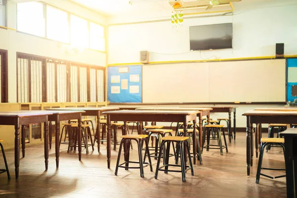 Lecture room or School empty classroom with desks and chair iron wood for studying lessons in high school thailand, interior of secondary education, with whiteboard, vintage tone educational concept