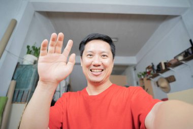 Mutlu blogcu gülümseyerek el sallıyor, web kamerası kayıt vlog 'uyla konuşuyor, sosyal medya etkileyicisi yayında, evde video görüşmesi yapıyor. Vesikalık portre. Web kamerası görünümü